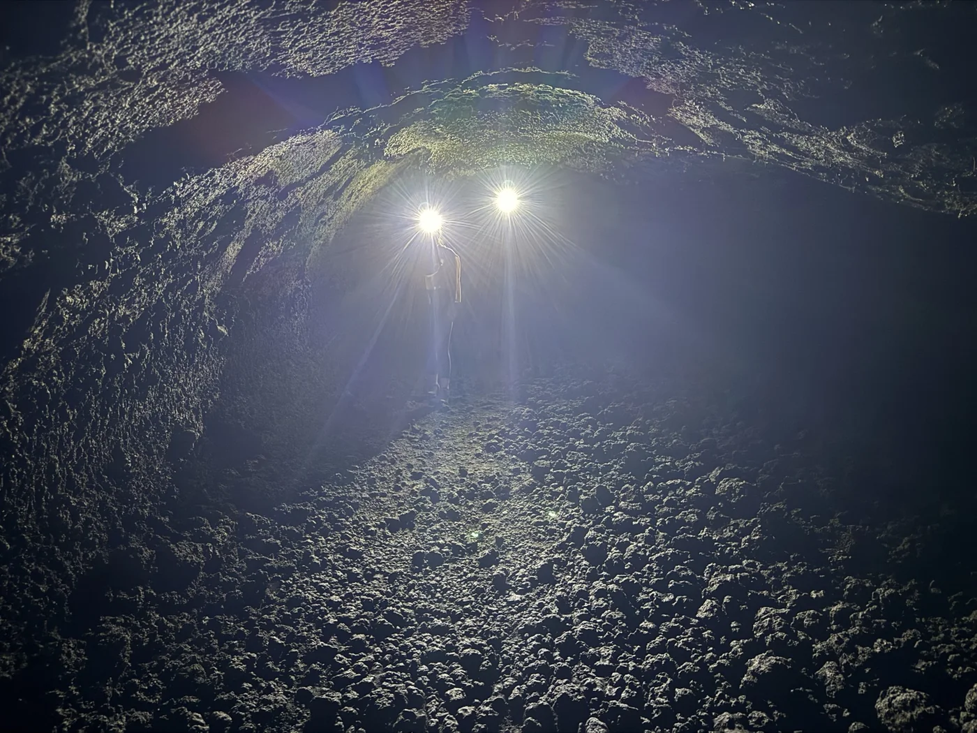 Interior of a Mount Etna lava tube illuminated by hiking headlamps