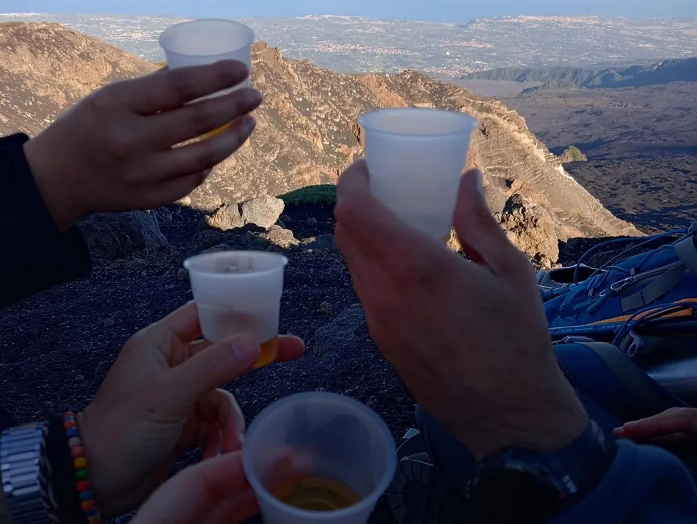Travellers raising a toast at the end of a hiking experience on Mount Etna